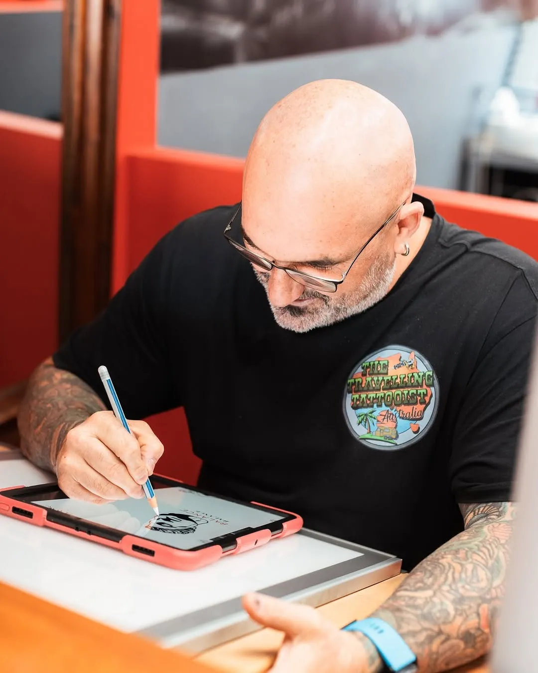 A Southside Tattoo artist drawing a custom design on a tablet before a session